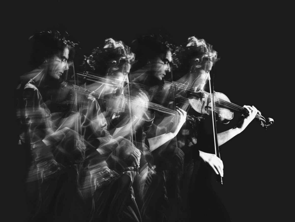 Multiple exposure of person playing violin dynamically.