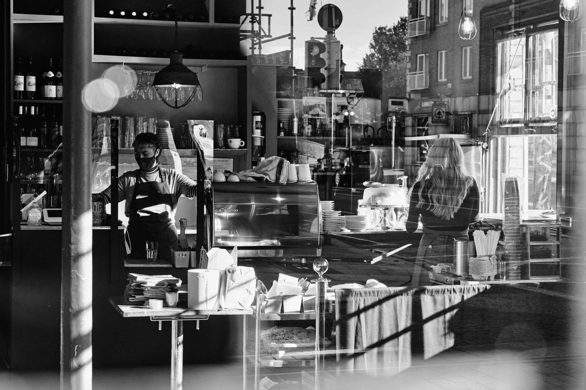 Busy cafe interior with people and reflections.