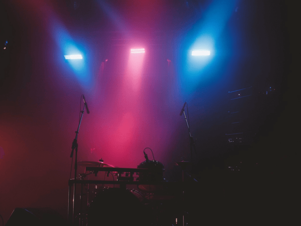 Empty stage with colorful lighting and microphones.