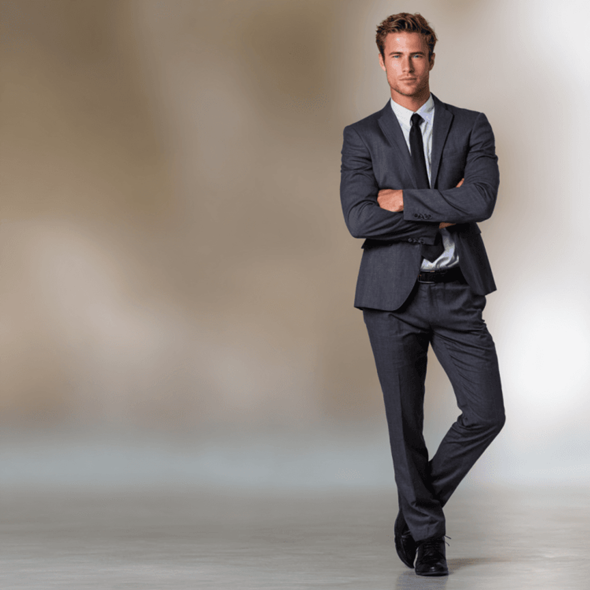 Man in gray suit standing confidently.