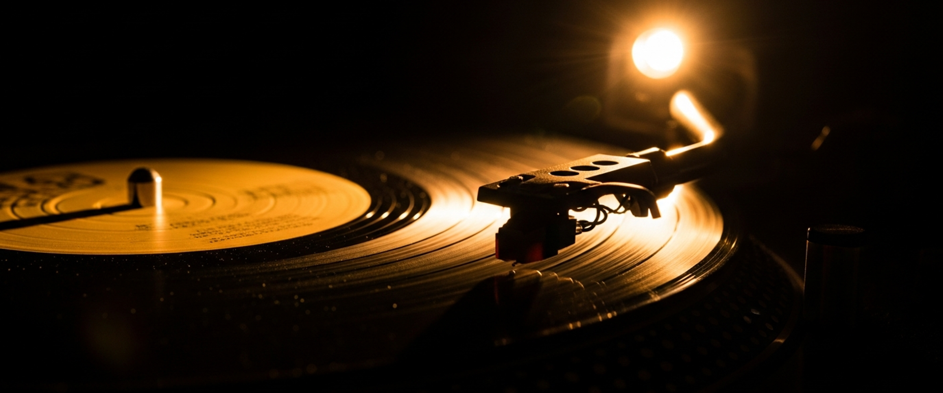 Vinyl record spinning on turntable with dramatic side lighting — comparing label services deals and traditional record label contracts