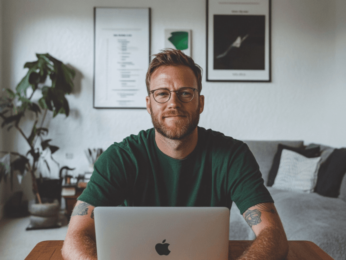 Smiling man with laptop at home office.