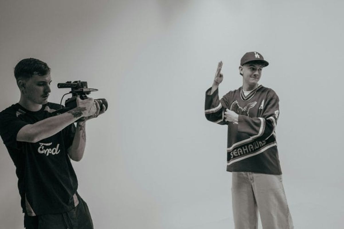 Videographer recording person in sports jersey.