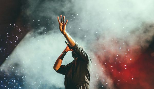 Live concert performance with dramatic stage lighting and crowd