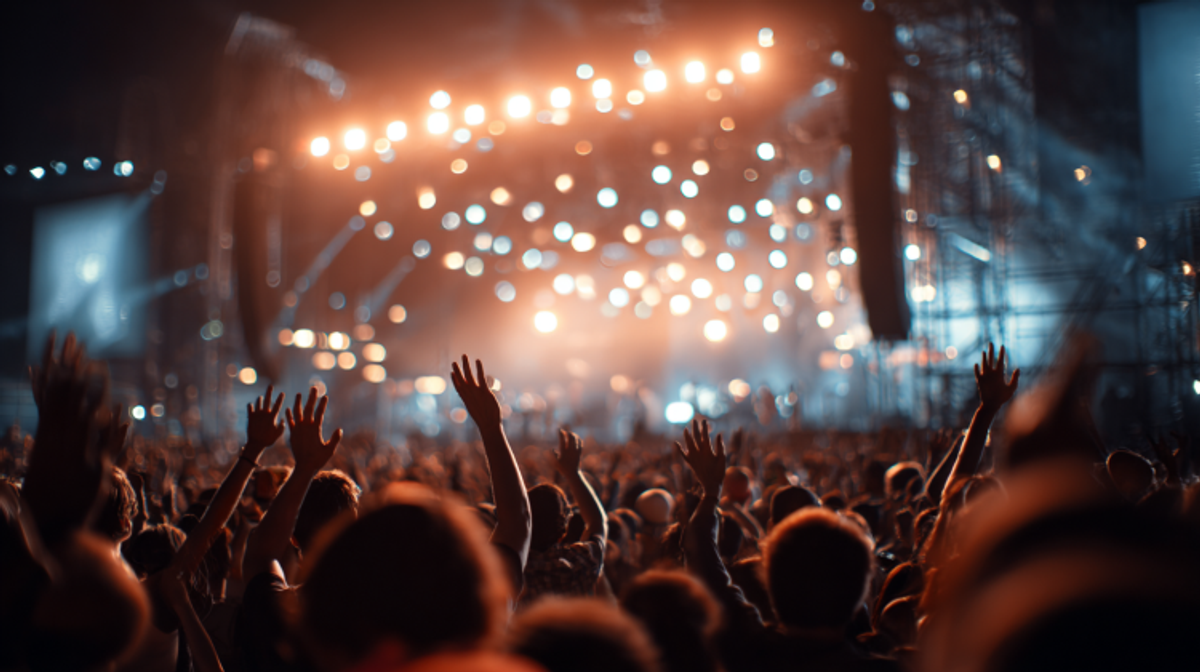 Crowd enjoying a lively concert with bright lights.