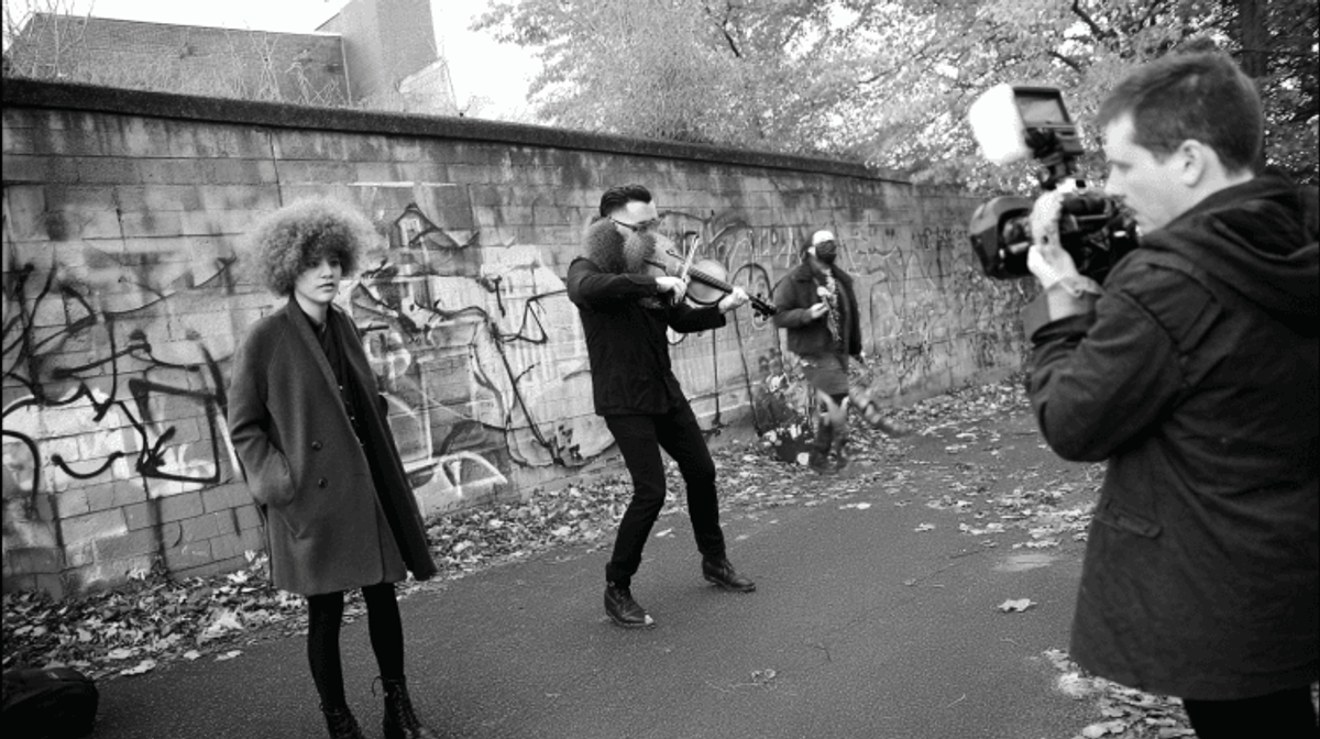 Street performance captured on camera with violinist.