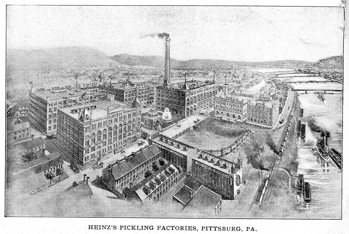Engraved bird's-eye view of a large complex of multi-story brick factory buildings with a tall smokestack beside a river with steamboats, a railway line and bridges, captioned Heinz's Pickling Factories, Pittsburg, Pa.