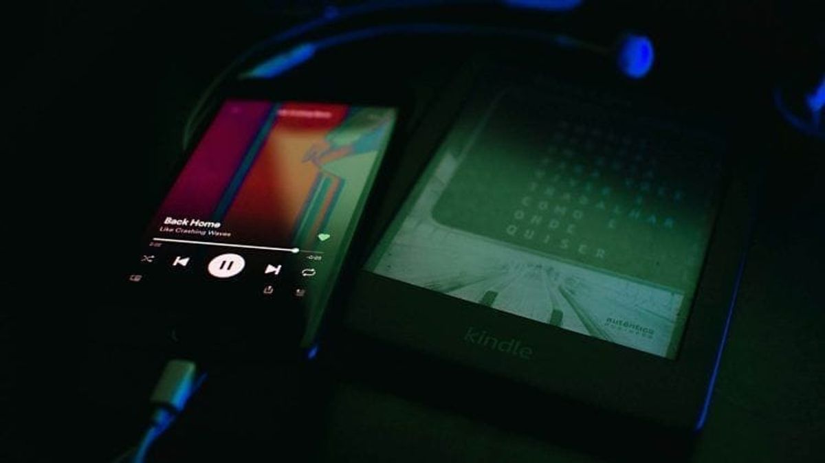 Phone playing music and Kindle e-reader