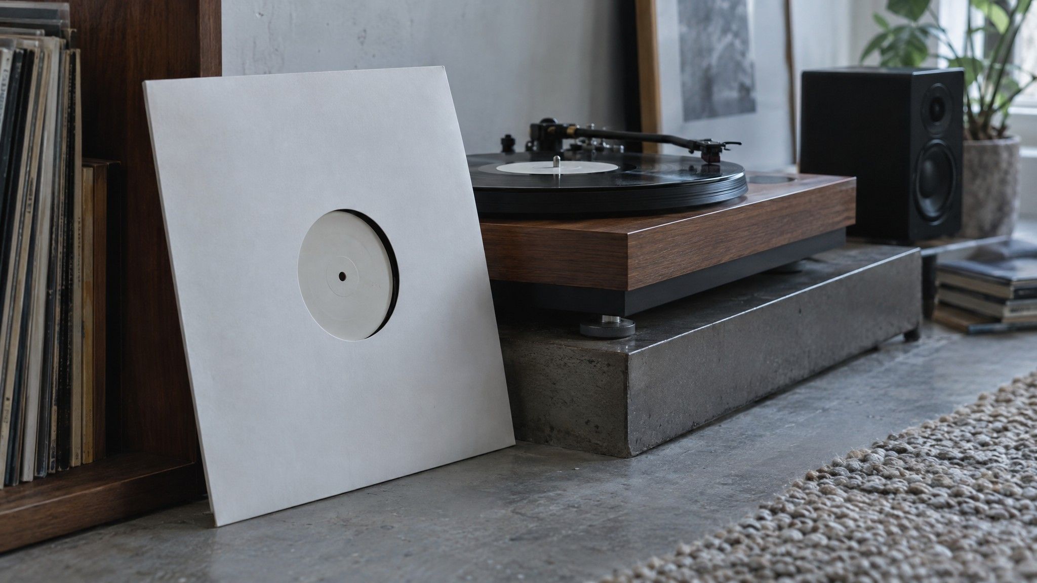 Plain white record sleeve leaning against a turntable