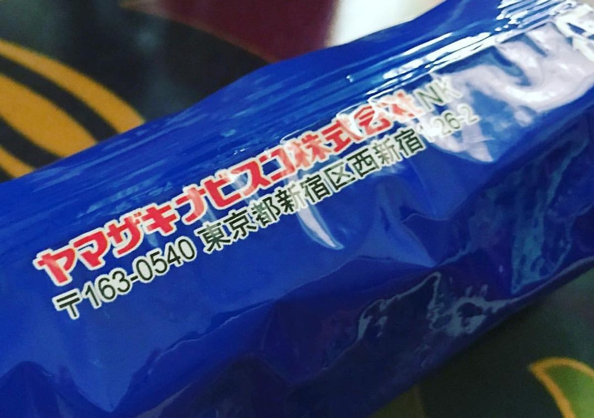 Close-up of a blue Japanese Oreo wrapper printed with the Yamazaki Nabisco company name and a Tokyo address