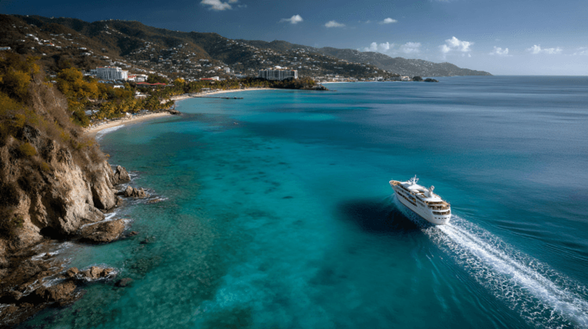 Cruise ship near tropical island coastline.