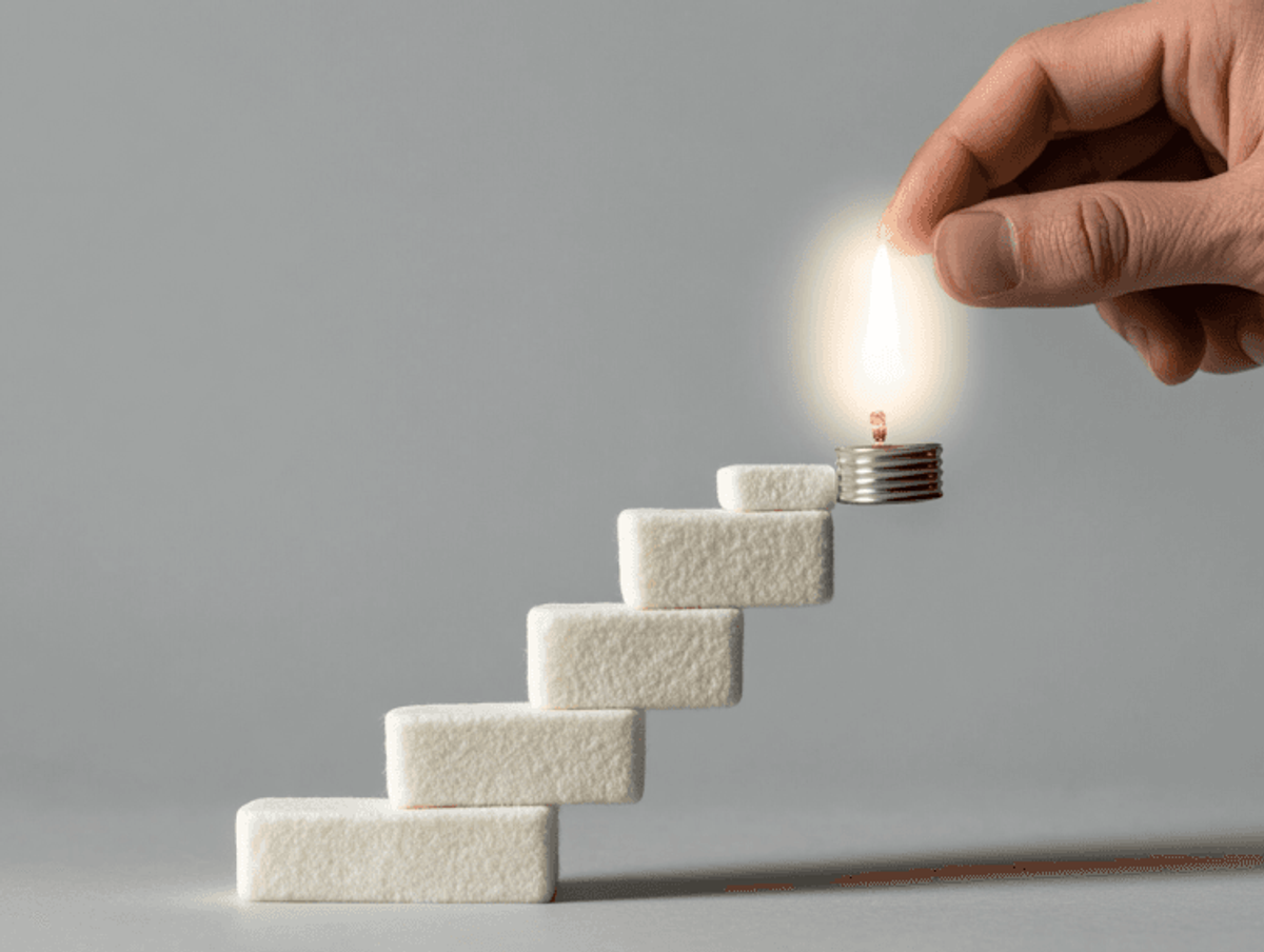 Blocks form stairs with hand holding candle.