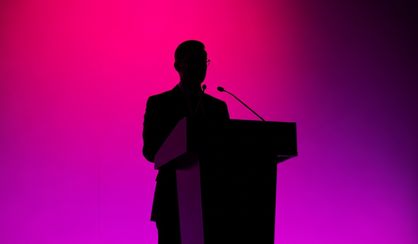 Professional at podium with dramatic stage lighting - crisis communications statistics