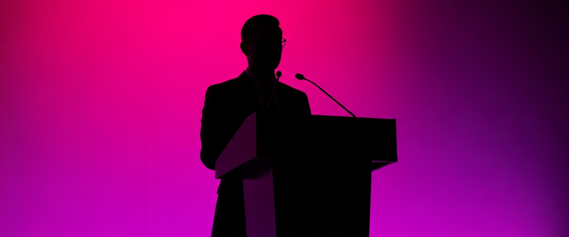 Professional at podium with dramatic stage lighting - crisis communications statistics