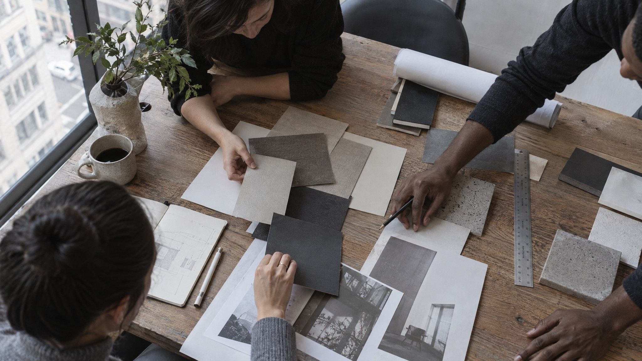 Paper stock samples, a steel ruler and pencil on a studio table