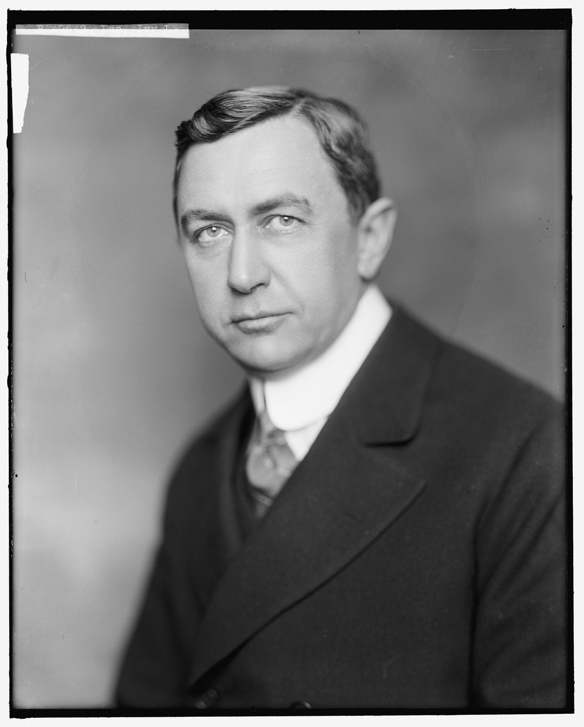 Black-and-white studio portrait of Ivy Lee, a man with short parted hair in a dark suit, white collar and patterned tie, looking toward the camera