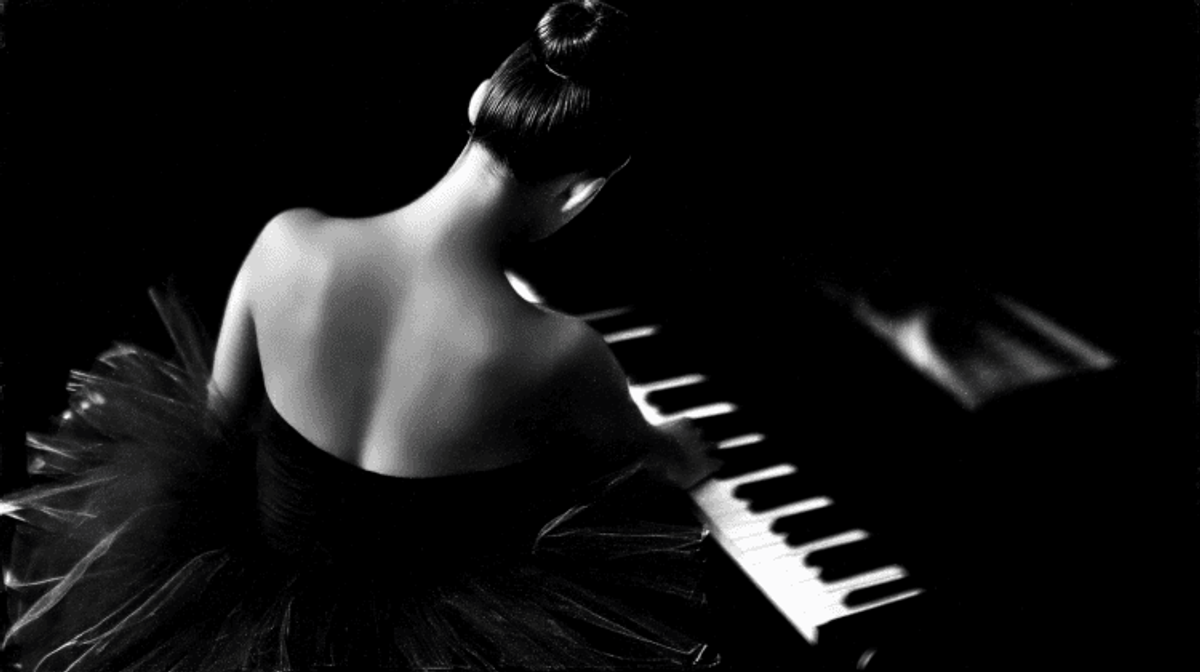 Ballet dancer in black dress playing piano.