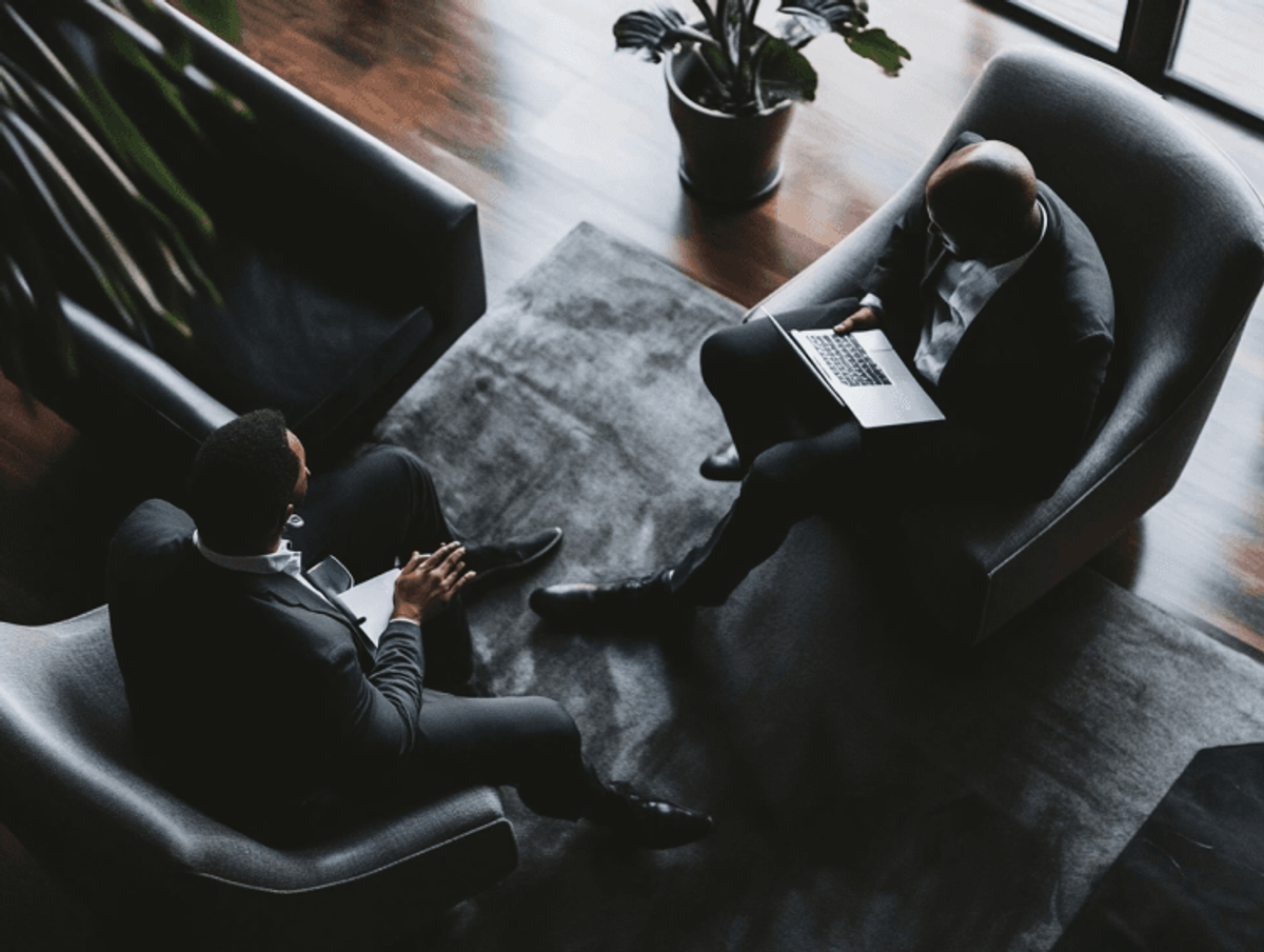 Two businessmen discussing in modern office lounge.