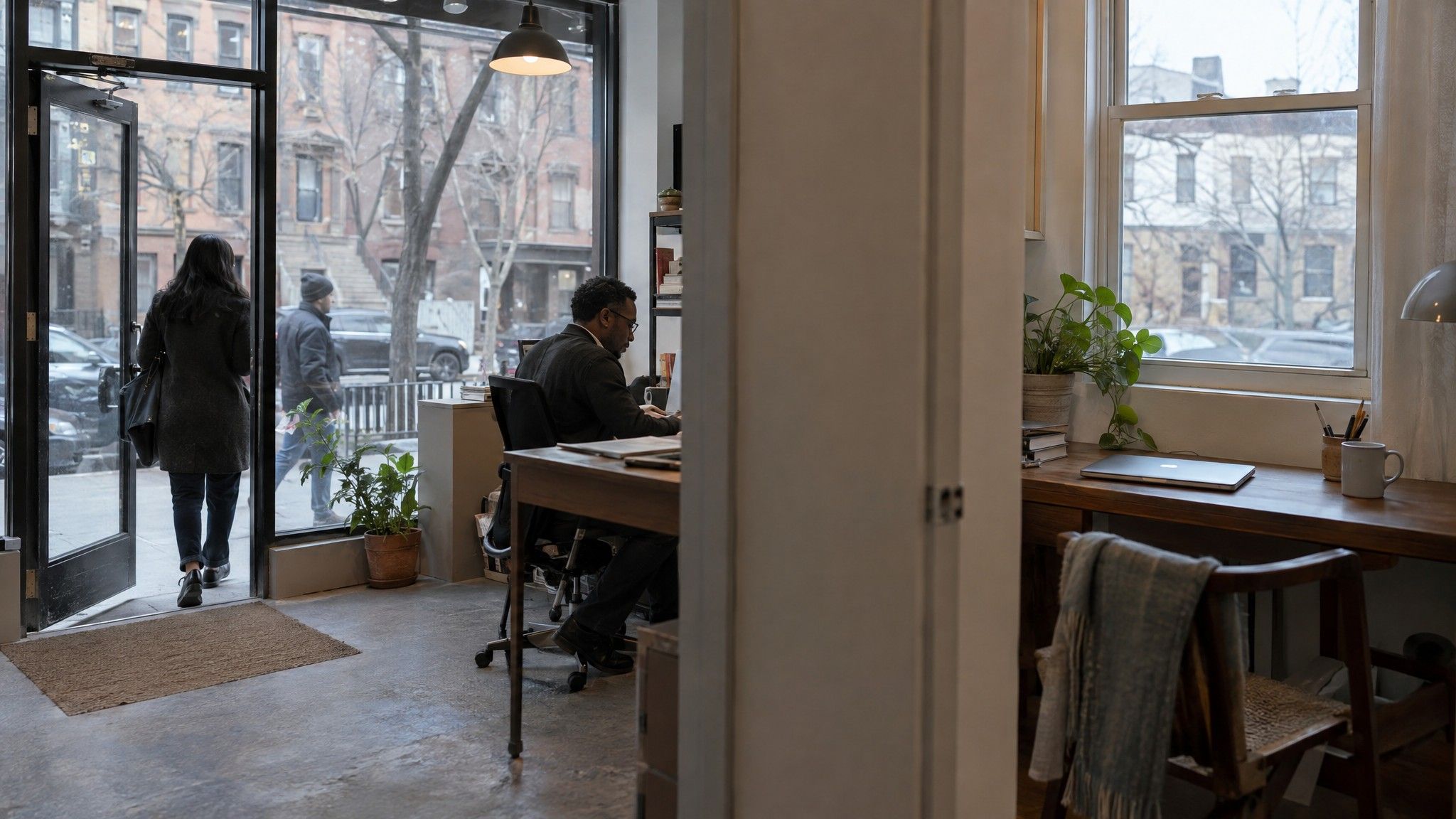 Street-level office door beside a home desk with a closed laptop