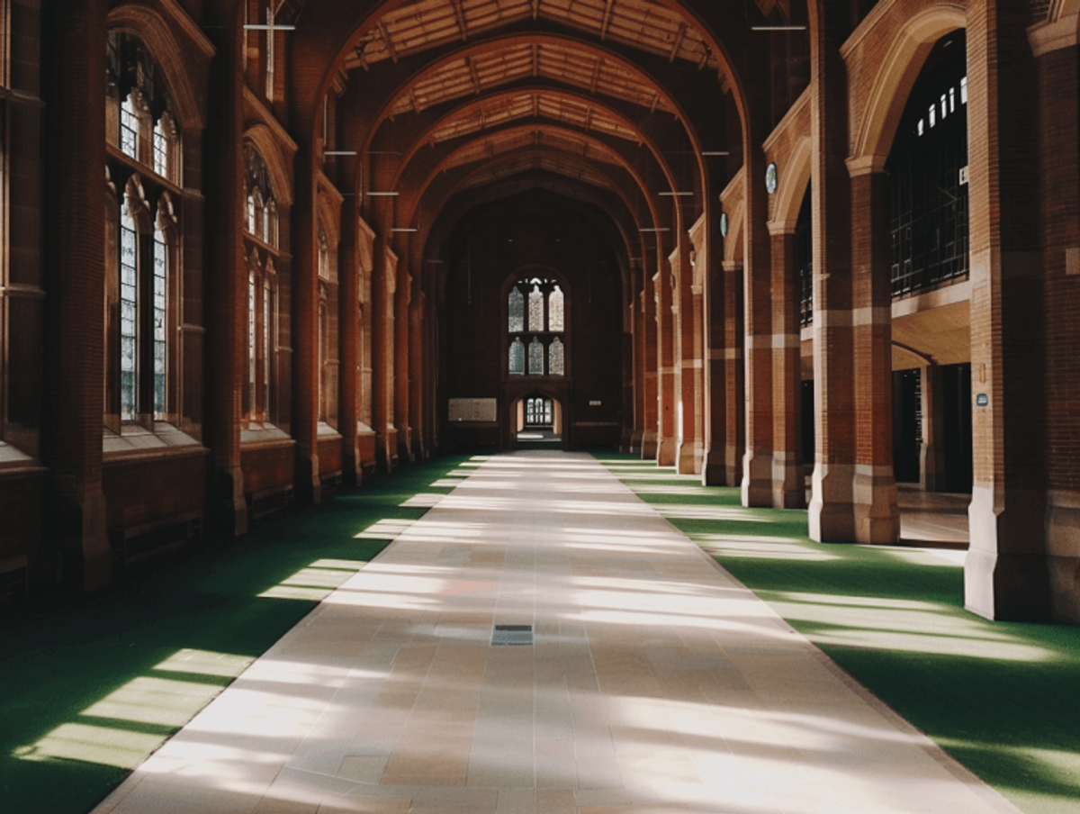 Sunlit cathedral hallway with arched windows.