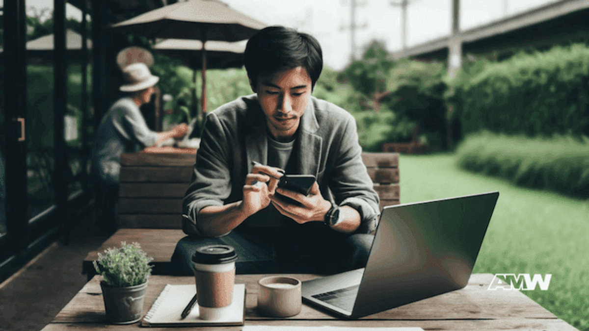 Man working on laptop outdoors with coffee.