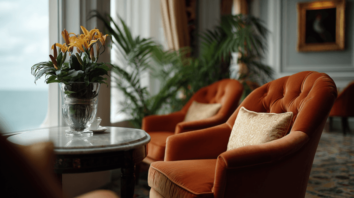 Cozy room with orange chairs and sea view.