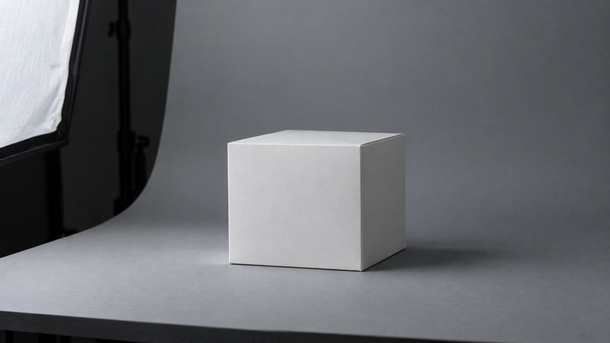 Unbranded white box on a grey paper sweep in a dark studio
