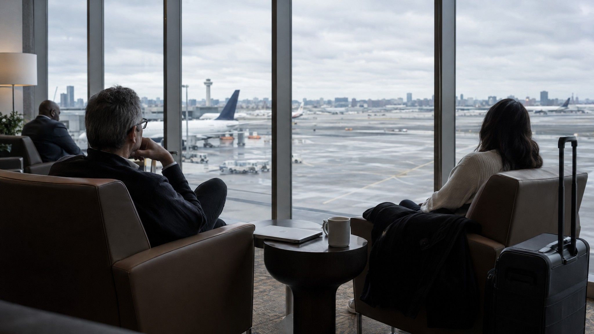 Airport business lounge with a closed laptop and coffee by a window