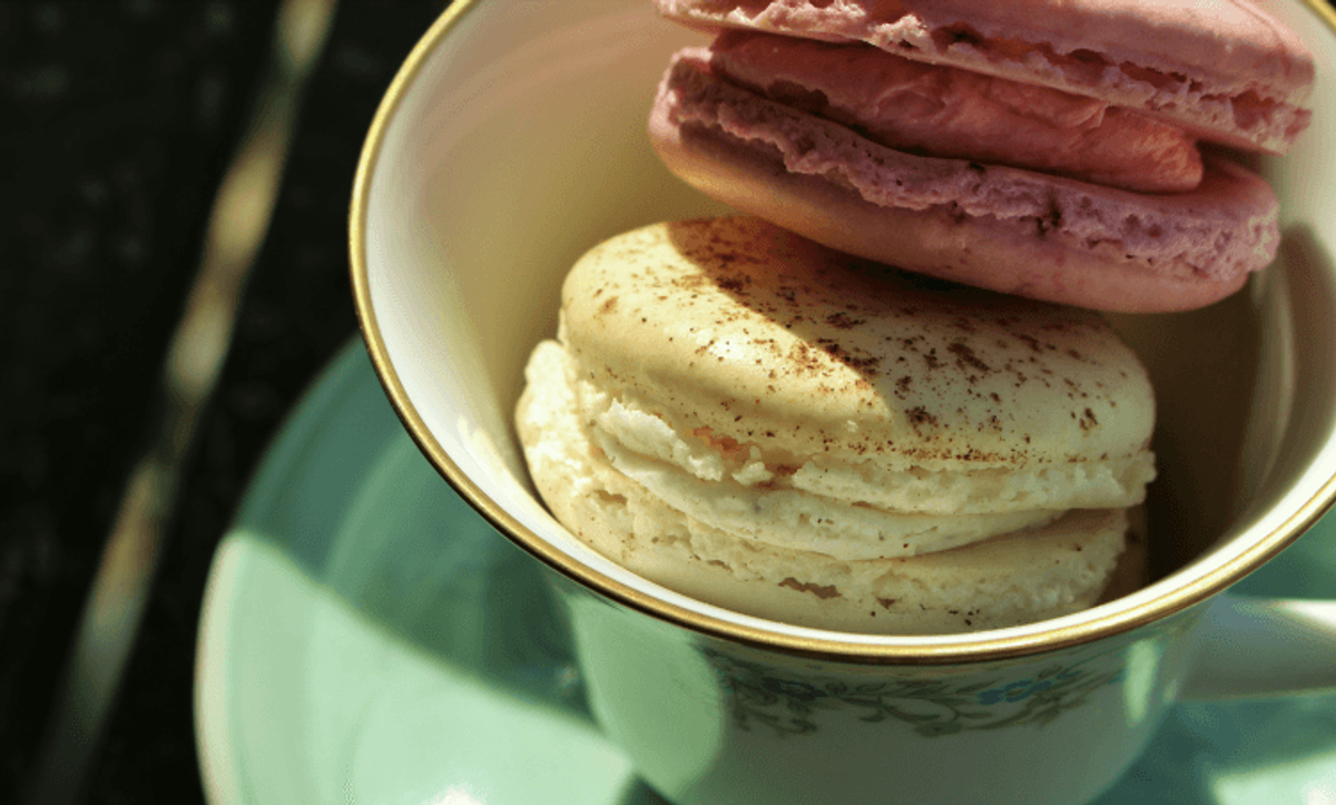 Colorful macarons in elegant teacup