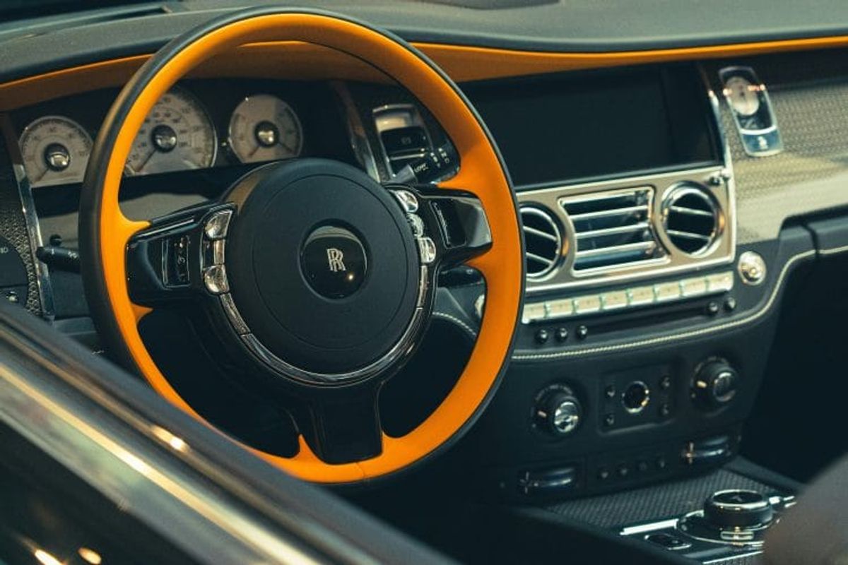 Luxury car interior with orange steering wheel
