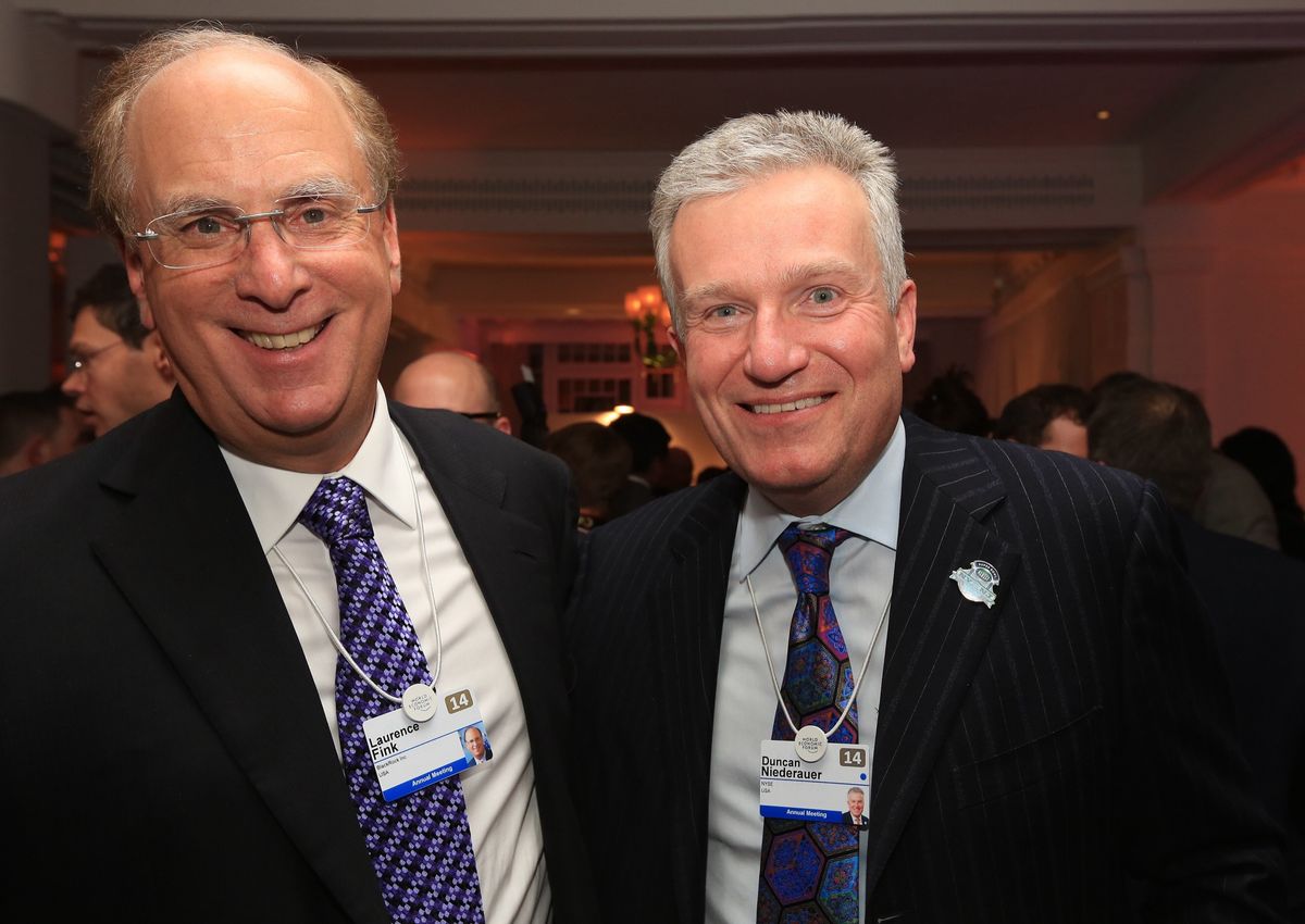 Larry Fink and Duncan Niederauer smiling side by side at an evening reception, both wearing World Economic Forum name badges