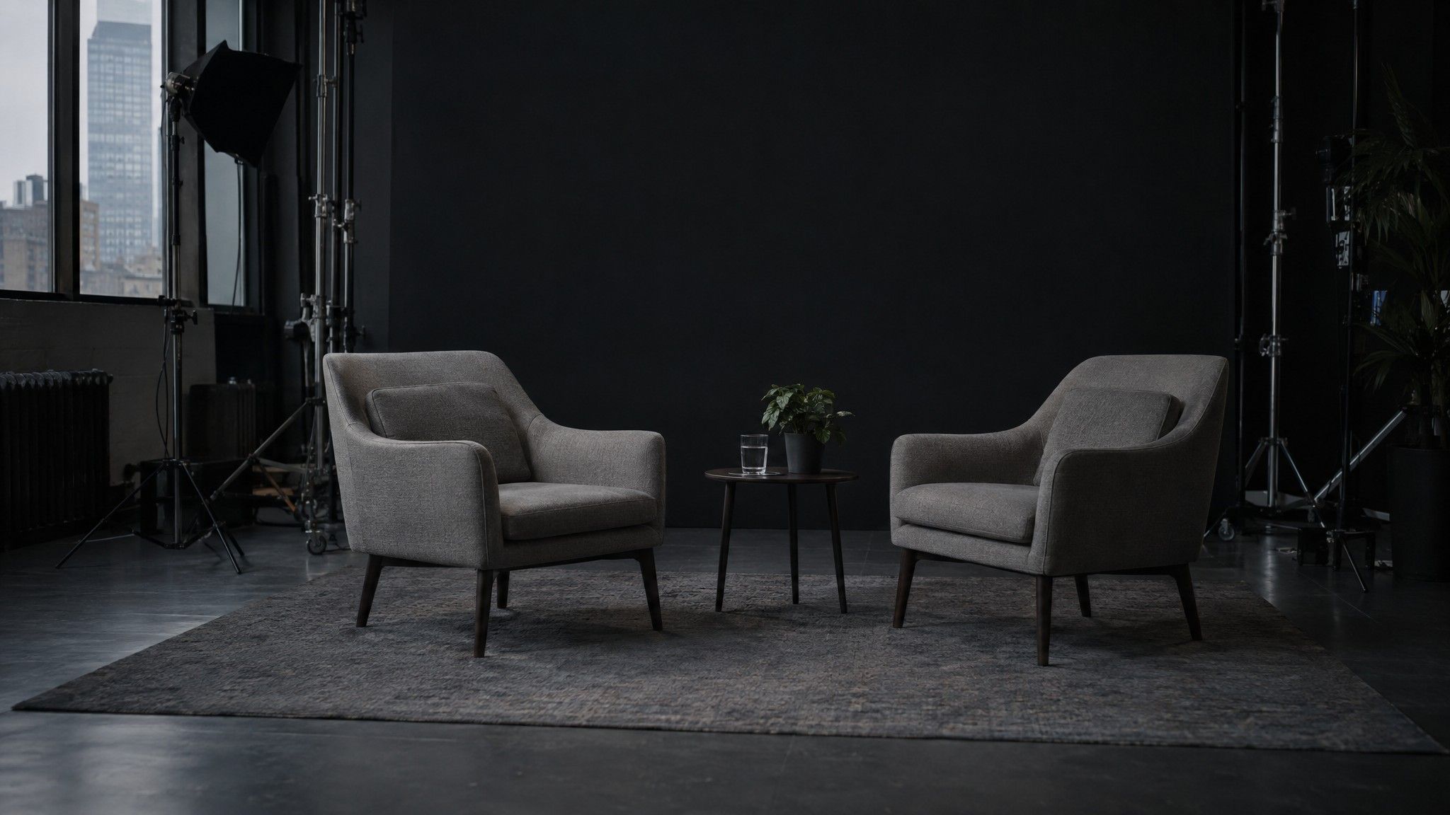 Empty TV interview set with two chairs and a glass of water