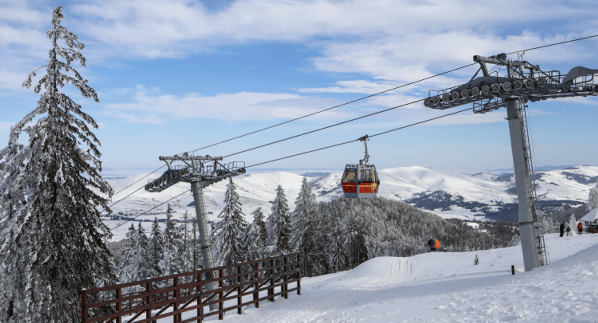 Ski lift over snowy mountain landscape.