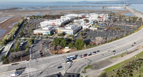 Aerial view of Meta's headquarters campus in Menlo Park beside a highway and the salt marshes of San Francisco Bay