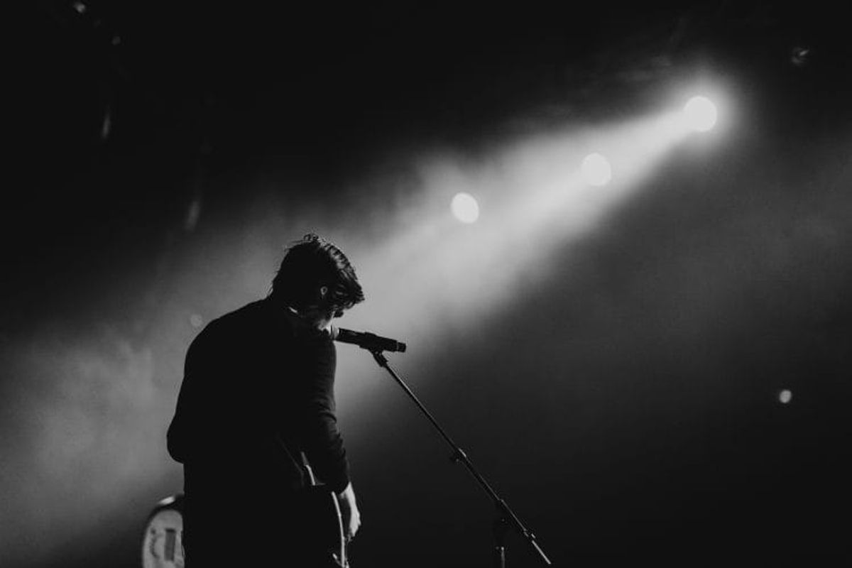 Singer performing on stage with spotlight