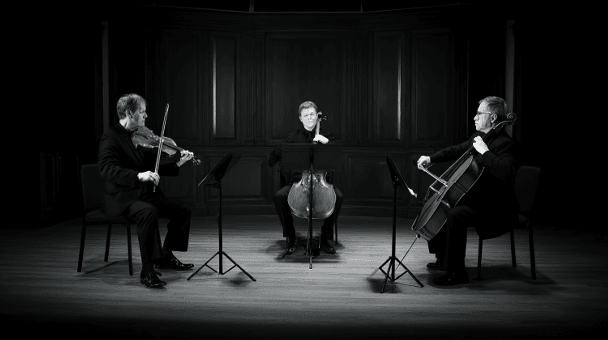 String trio performing on stage with instruments.