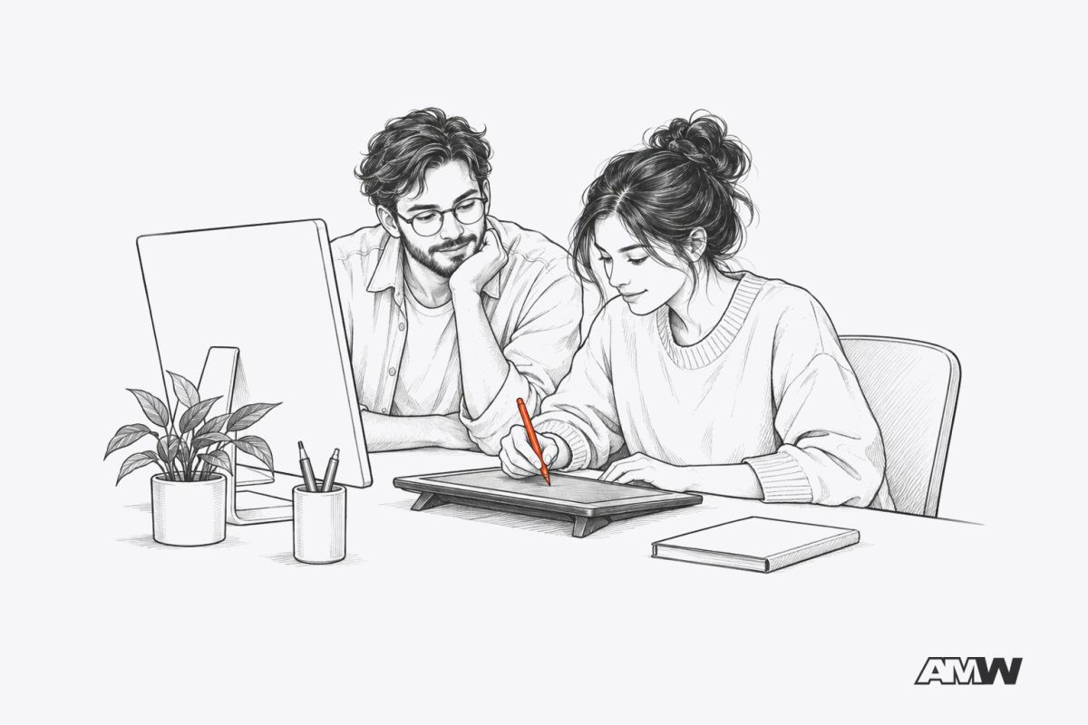 Two colleagues at a shared desk, one working with a stylus while the other learns the method