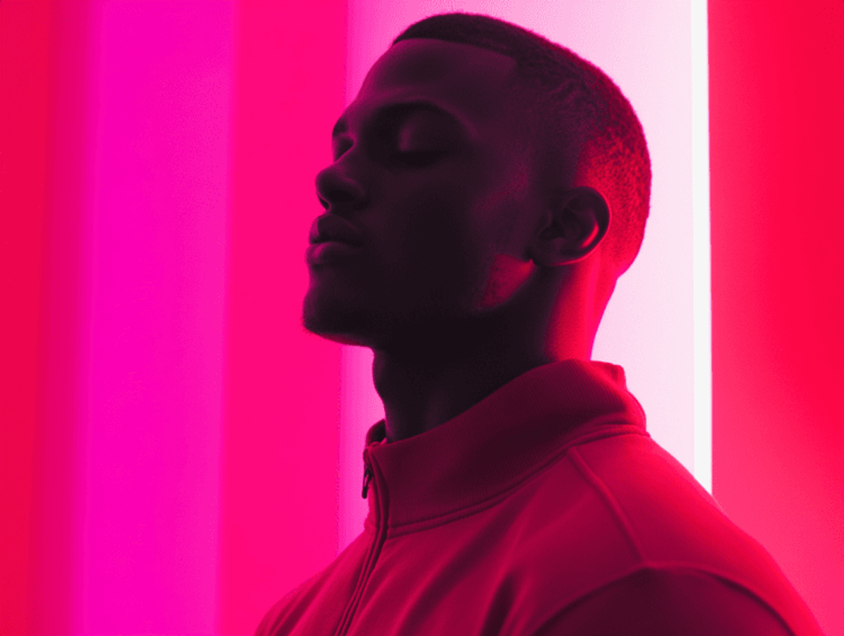 Person in red lighting, eyes closed.