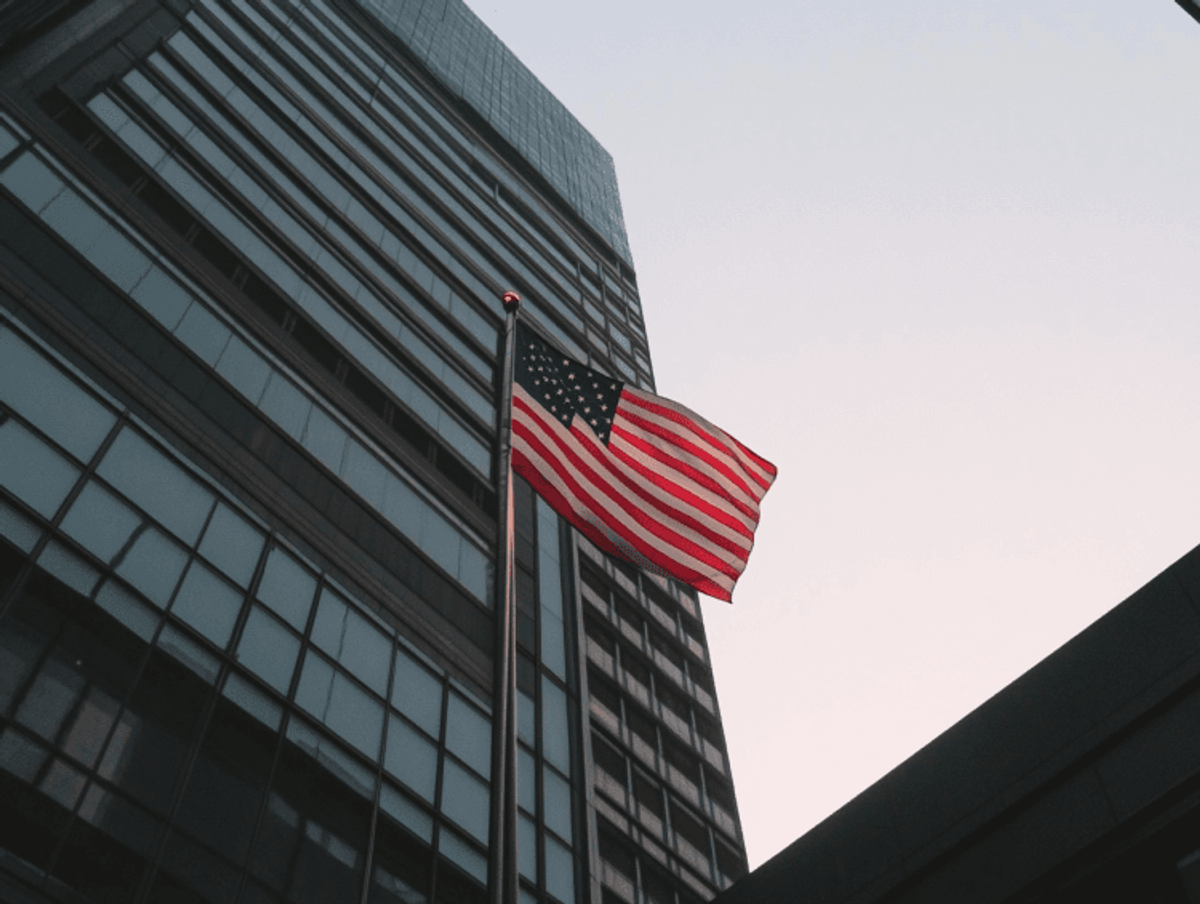 American flag waving near tall building
