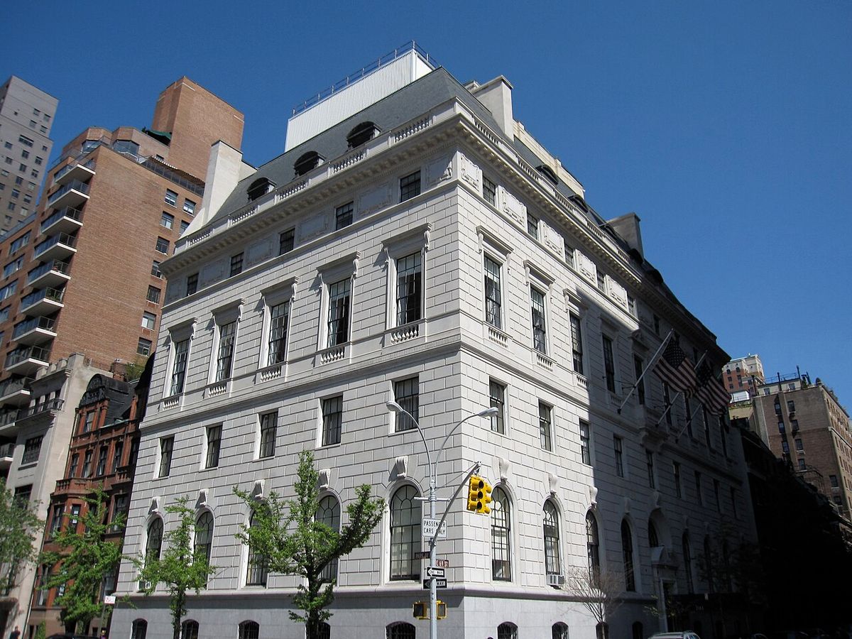 The Union Club's pale stone clubhouse on the corner of Park Avenue and East 69th Street, with arched ground-floor windows and American flags