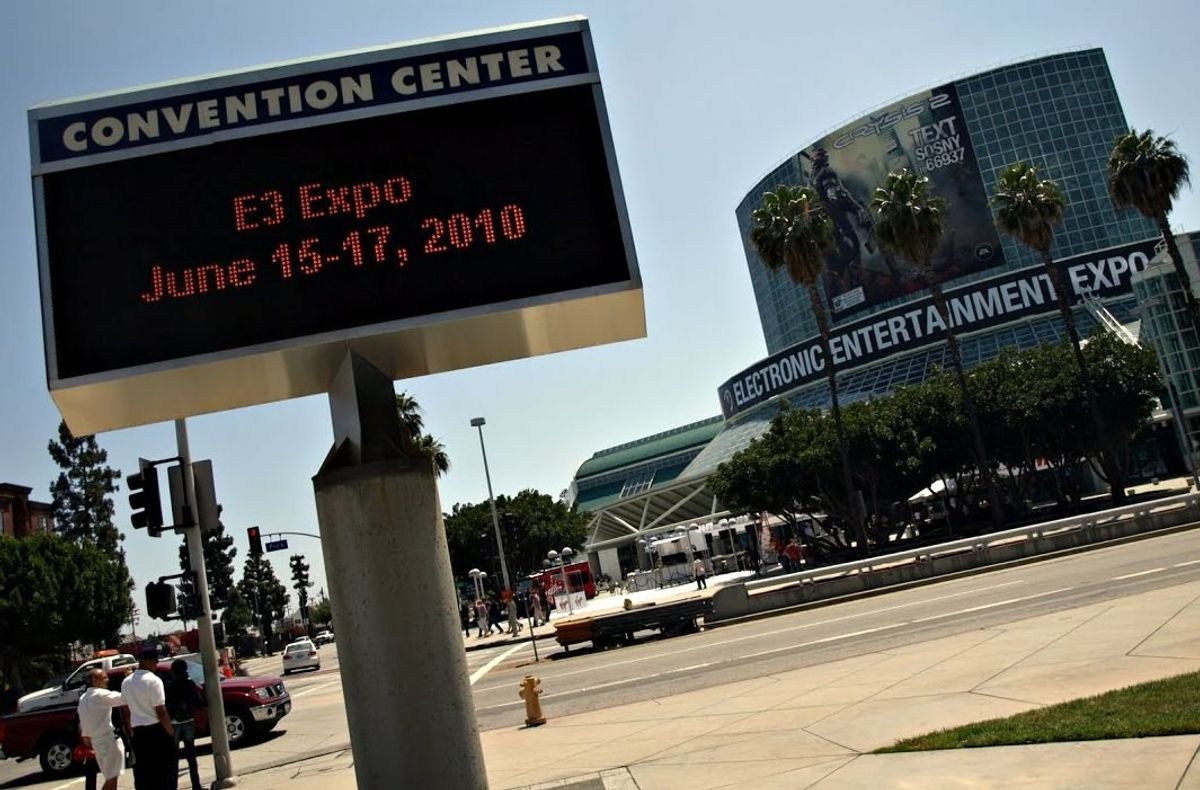 A roadside Convention Center sign reading "E3 Expo June 15-17, 2010" in front of the Los Angeles Convention Center, whose glass front carries an Electronic Entertainment Expo banner