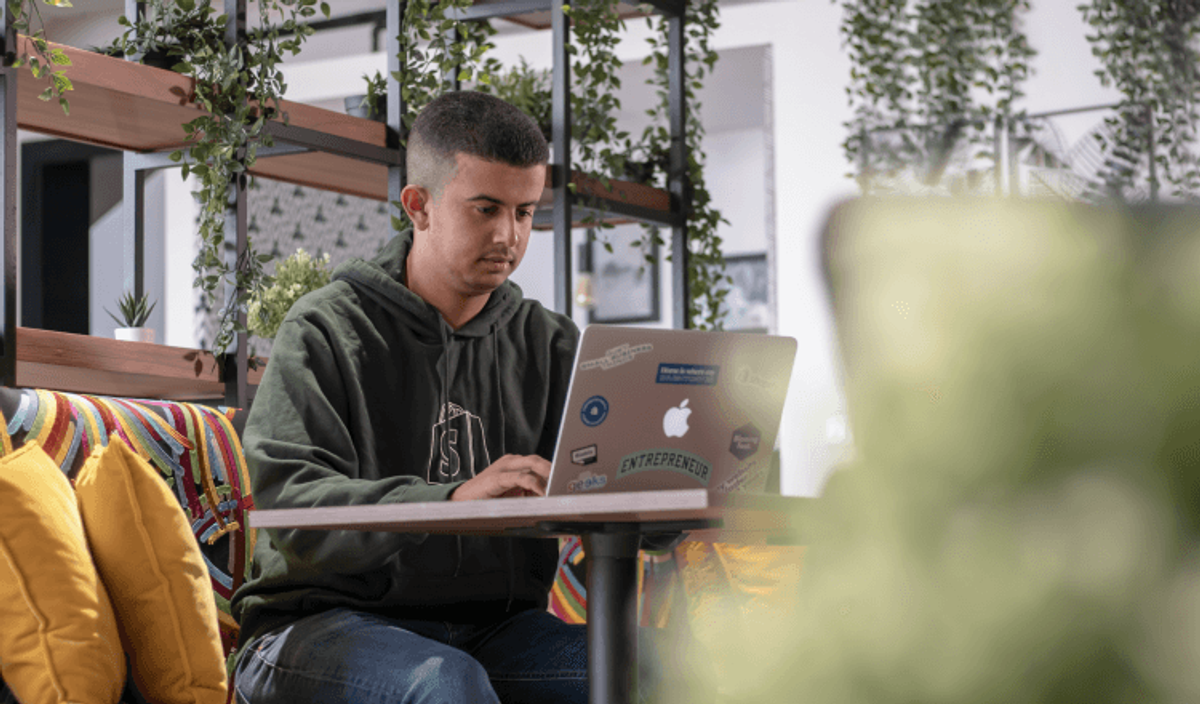 Man working on laptop in green space