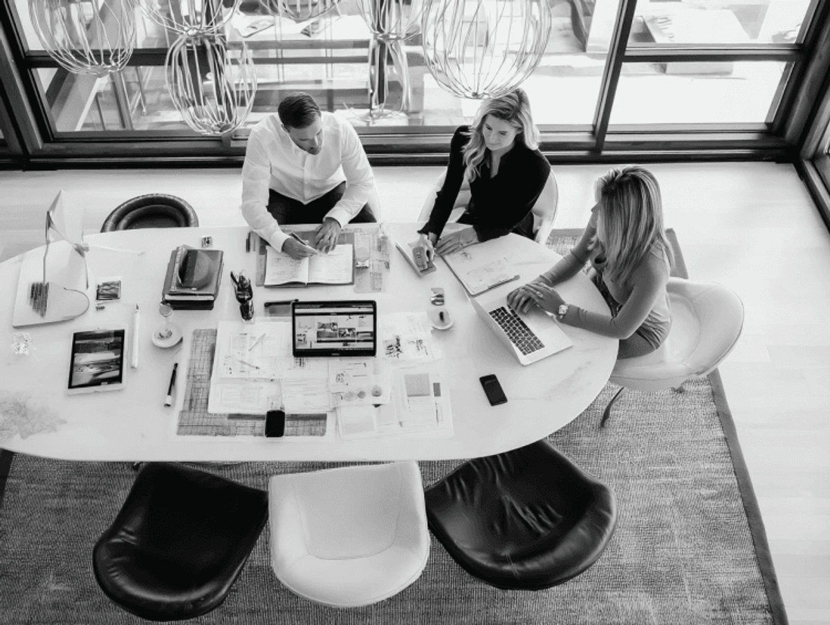 Team collaborating in modern workspace with laptops.