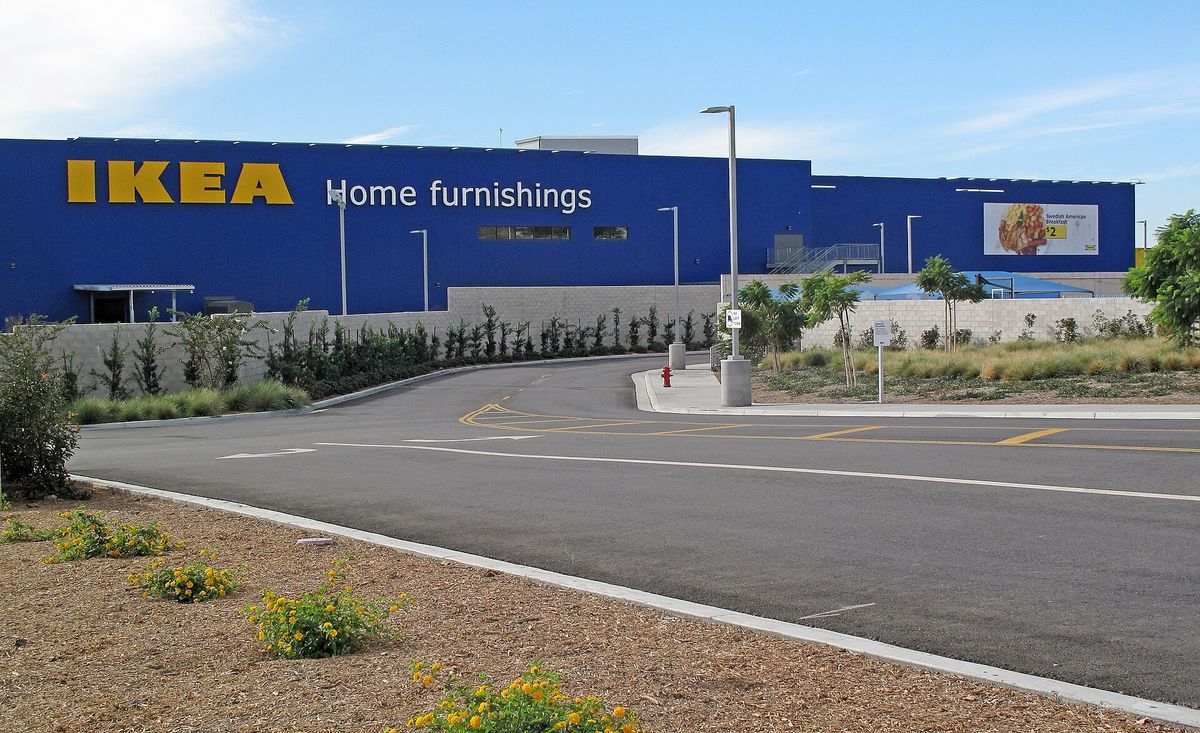 The long blue wall of the IKEA store in Burbank with a yellow IKEA sign and the words Home furnishings, seen across a curving access road with new landscaping
