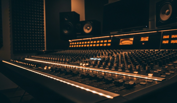 Music recording studio mixing console with warm ambient lighting