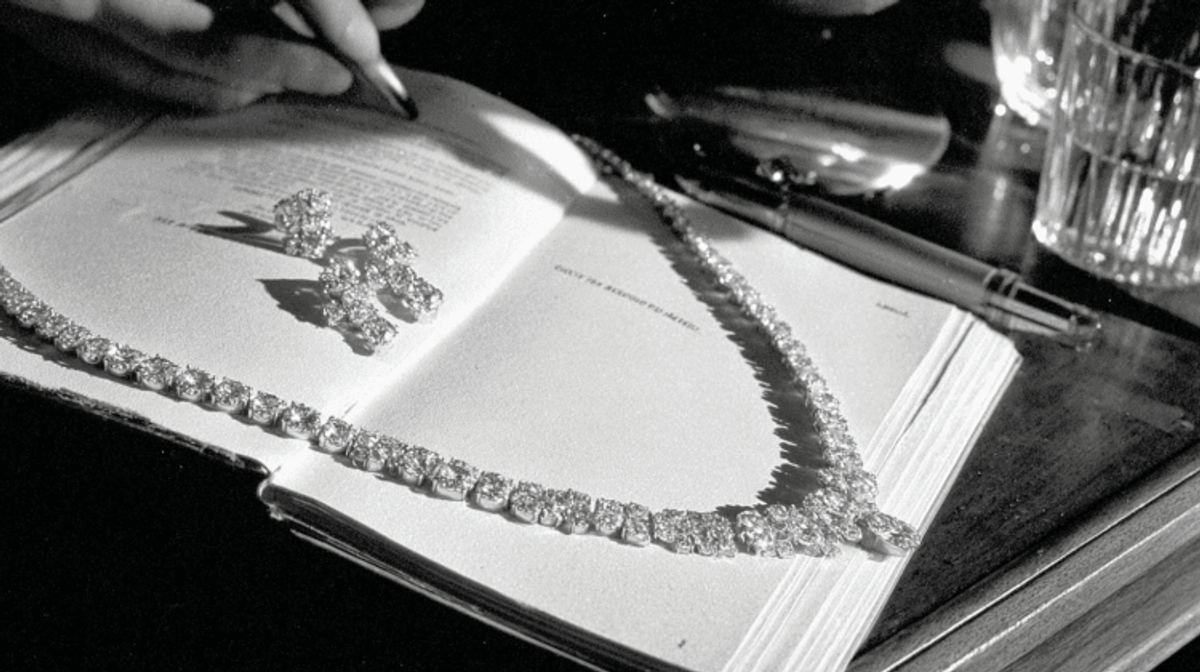 Diamond jewelry on open book with pen