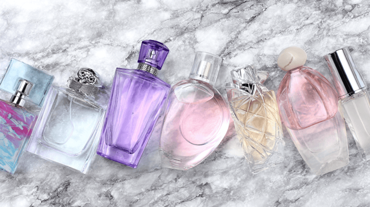 Colorful perfume bottles on marble background