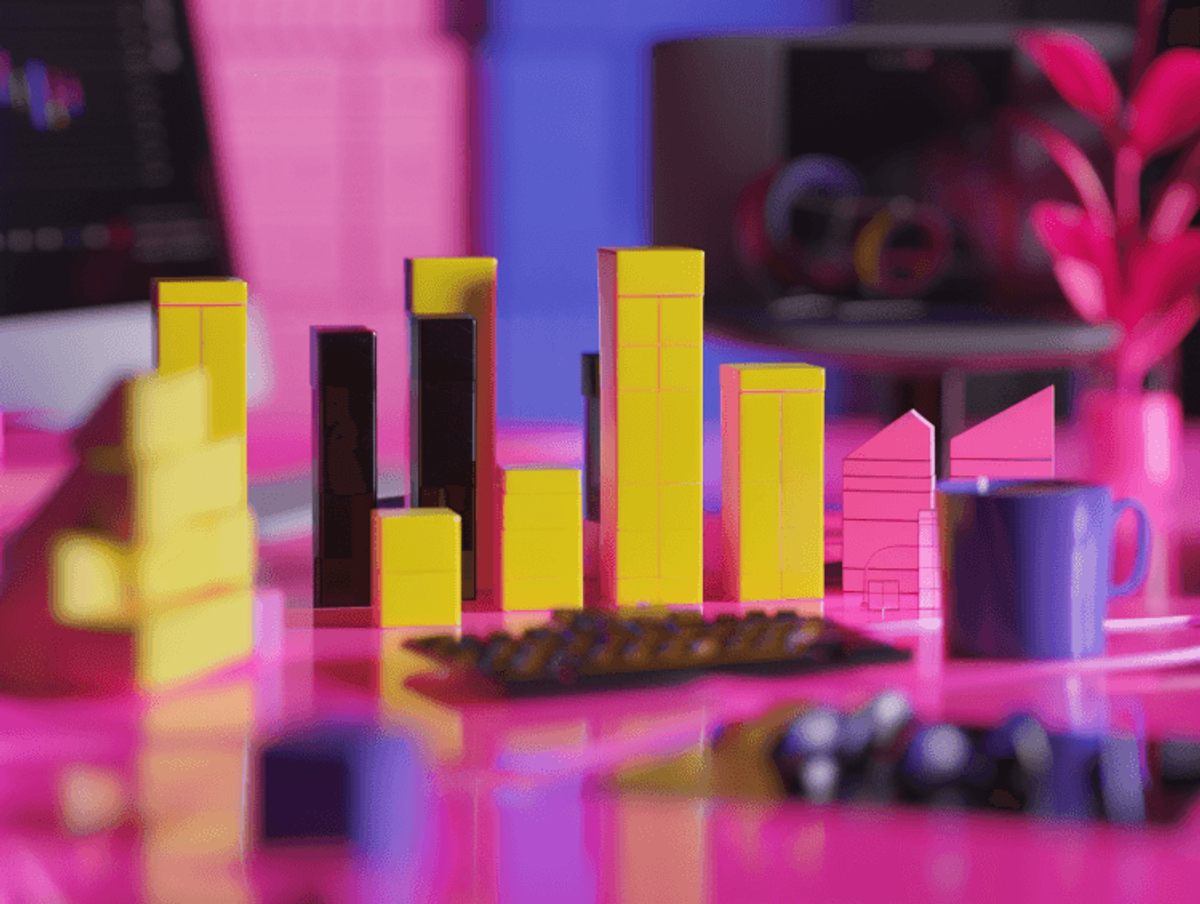 Colorful geometric blocks on vibrant pink workspace.