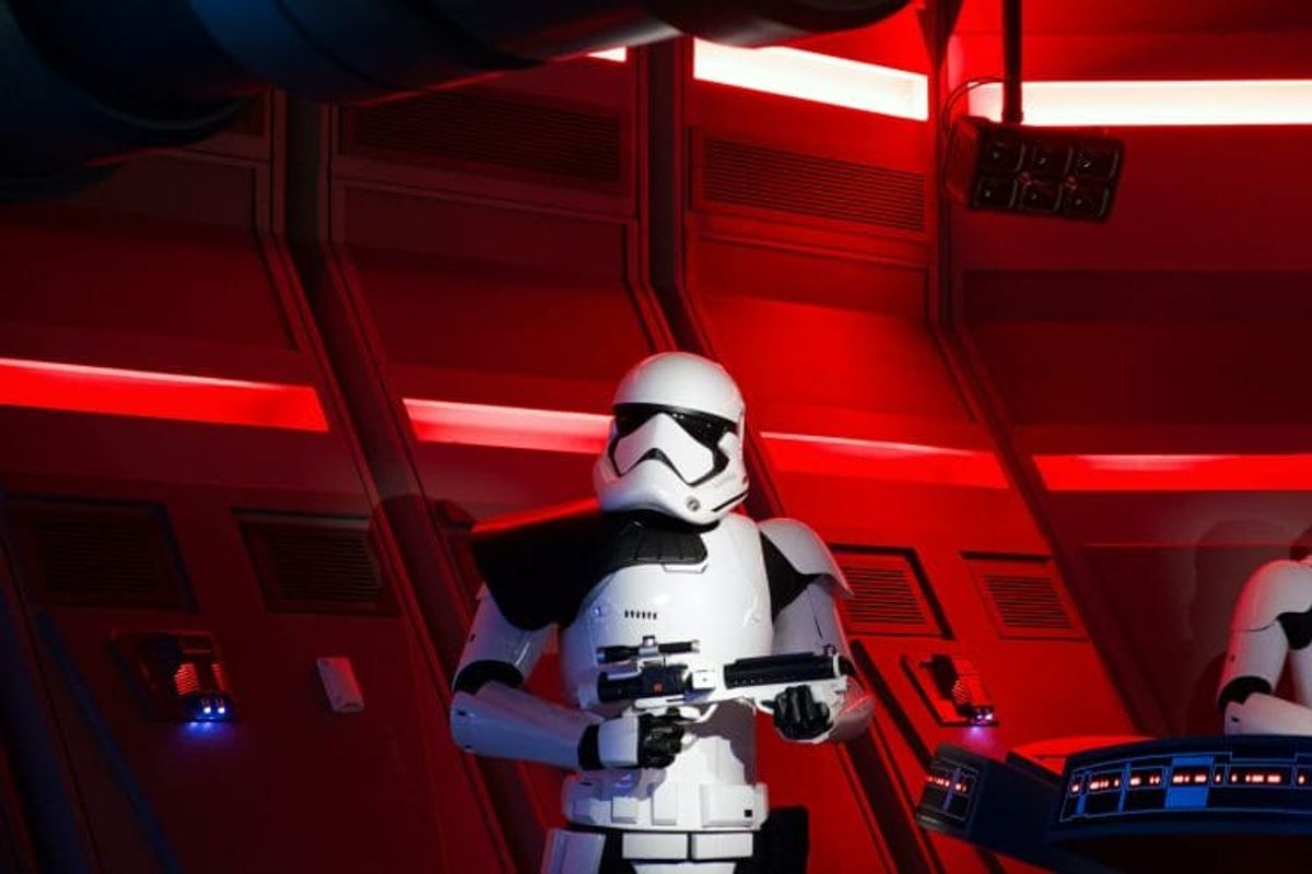 Stormtrooper in red-lit starship corridor scene.
