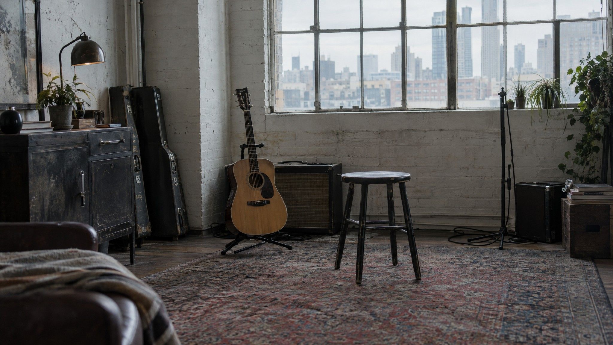 Rehearsal room with a guitar on a stand, amp and stool